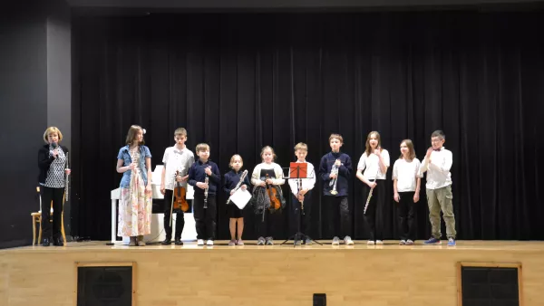 Zdjęcie grupowe artystów po występie dla uczniów klas 1-3 razem z prowadzącą nauczycielką. 