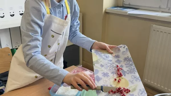 Uczennica przygotowuje sałatkę owocową.