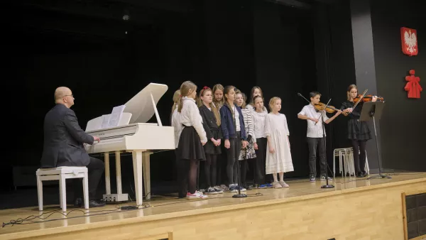 Schola szkoły podstawowej gra i śpiewa kolędy.