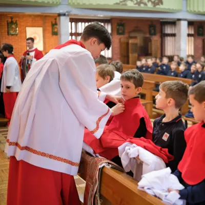 Nowi ministranci otrzymują peleryny i komże.