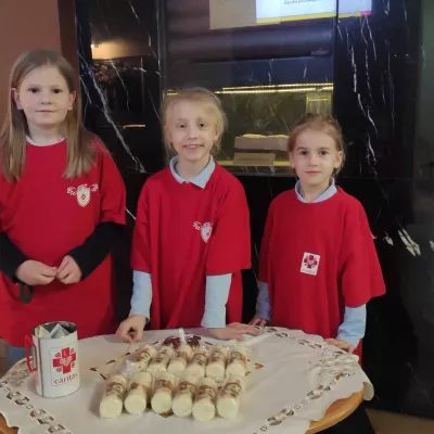 Wolontariuszki SKC sprzedające świece w ramach akcji Wigilijne Dzieło Pomocy Dzieciom Caritas Polska 