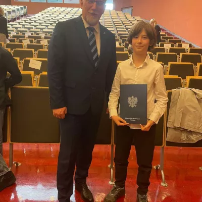 Aleksander van Rooy odbiera z rąk Łódzkiego Wicekuratora Oświaty zaświdaczenie o zdobyciu tytułu laureta w Wojewódzkim Konkursie Przedmiotowym 