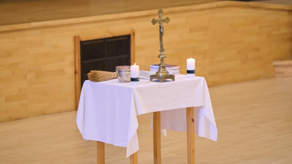 Stolik kolędowy: stół z białym obrusem, świece, krucyfiks i woda święcona. (fot. Amelia Szymańska)