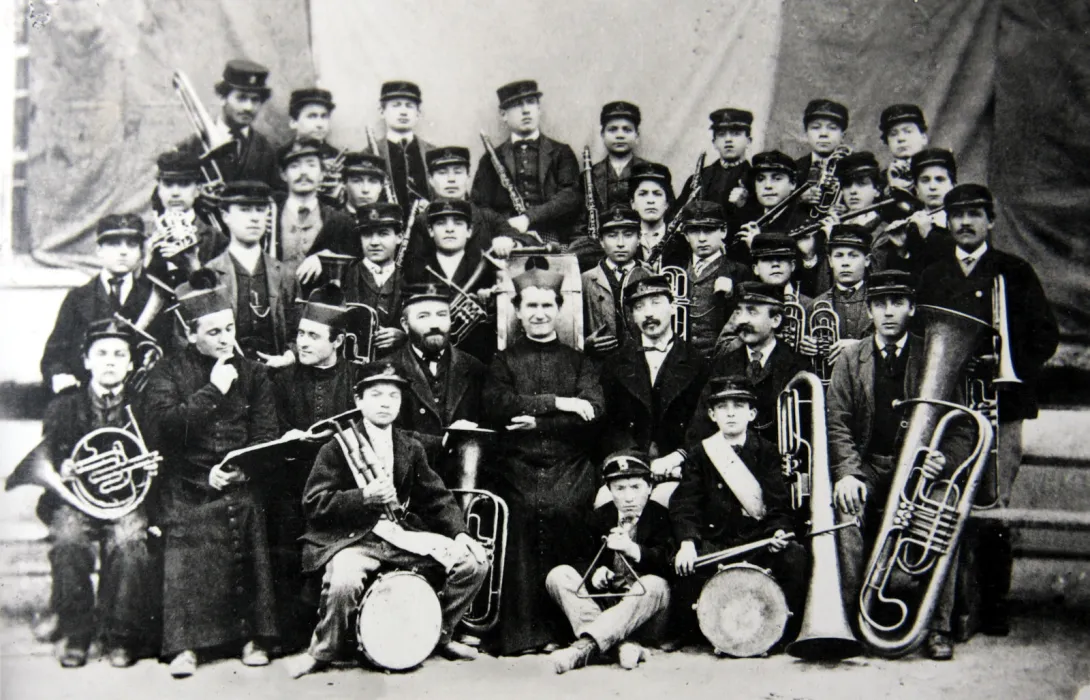 Ksiądz Bosko z orkiestrą. Na zdjęciu są uczniowie i nauczyciele szkoły muzycznej z oratorium na Valdocco. Fotografia z roku 1870 r.