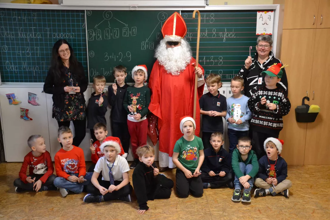 Wspólne zdjęcie uczniów i nauczycieli klasy 1b ze świętym Mikołajem.