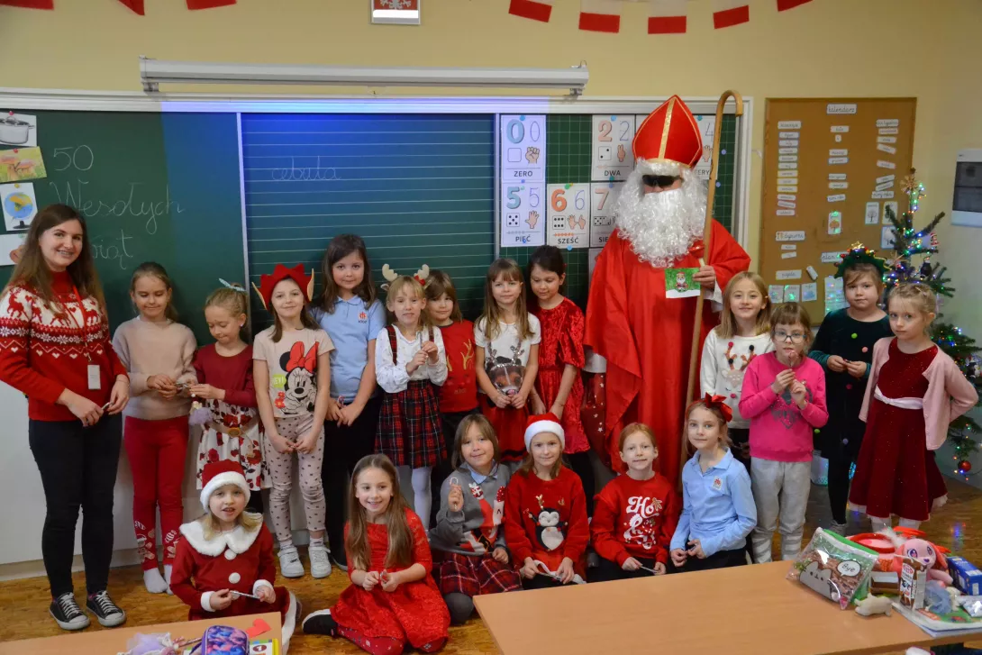 Wspólne zdjęcie uczennic i nauczycielki klasy 1c ze świętym Mikołajem.