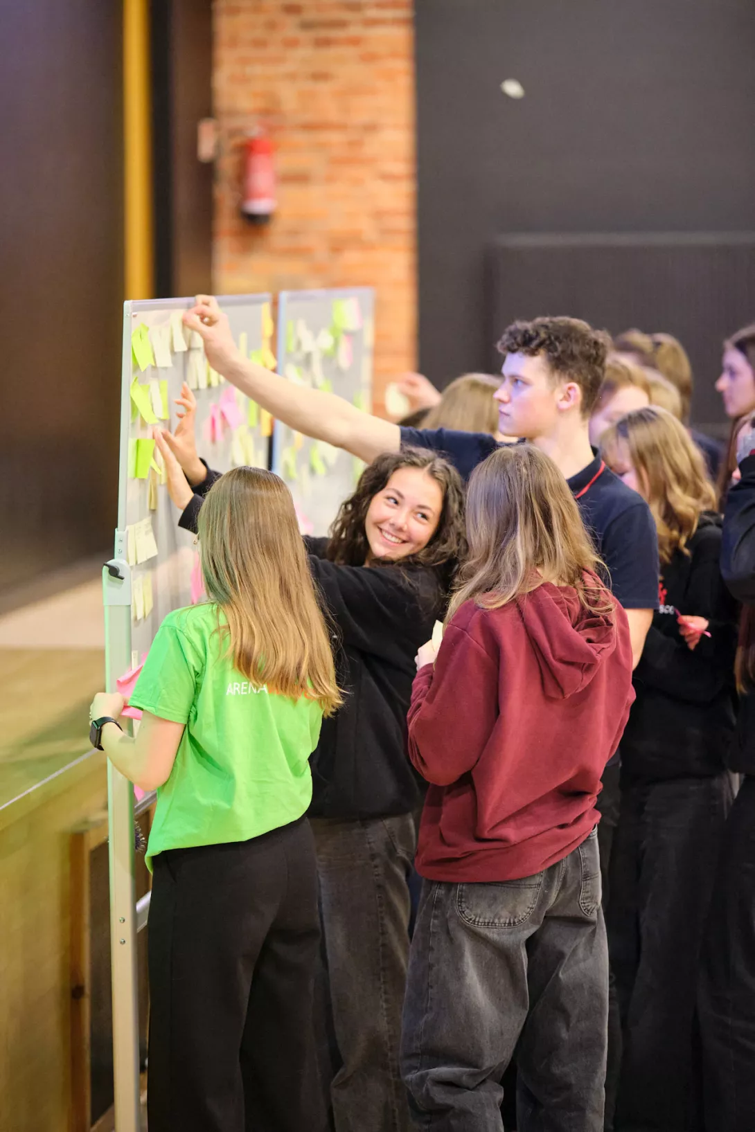 Uczniowie przyklejają karteczki z wynikami burzy mózgów. (fot. Amelia Szymańska)