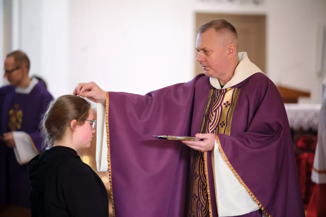 Ks. Dariusz Husak posypuje głowy uczniów popiołem. (fot. Amelia Szymańska)