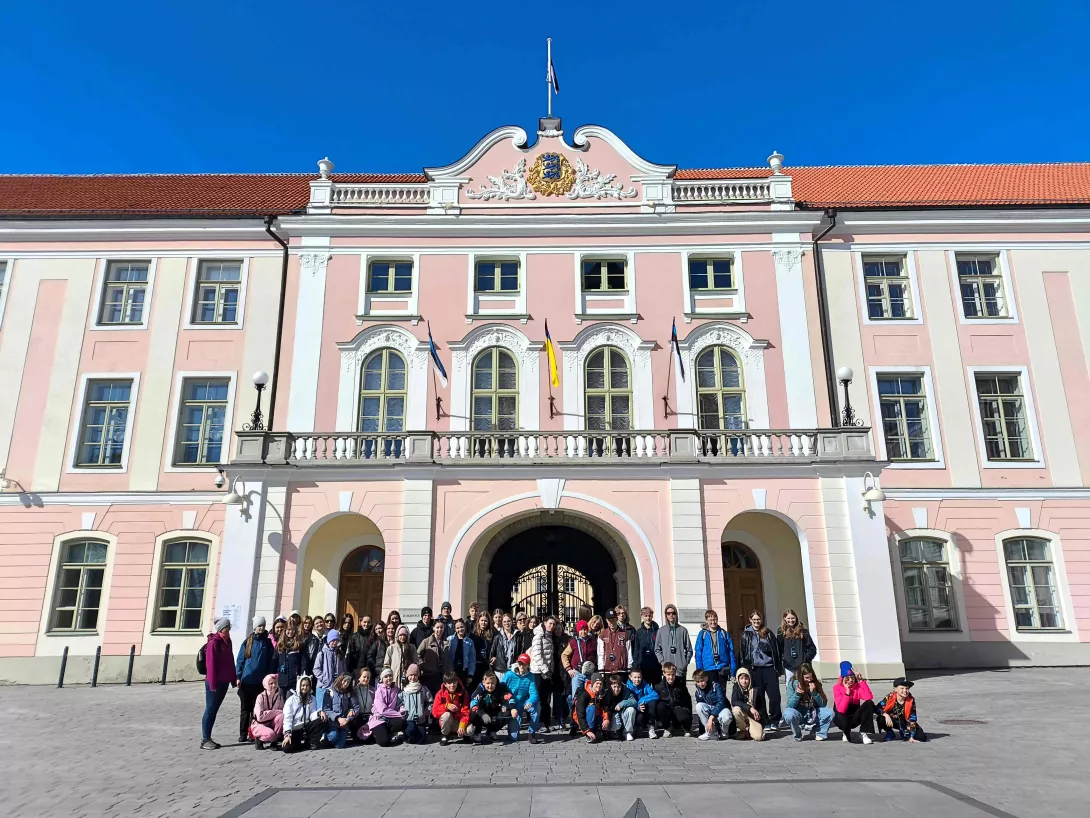 Zdjęcie grupowe uczestników wycieczki w Tallinie, na tle budynku Parlamentu Estońskiego.