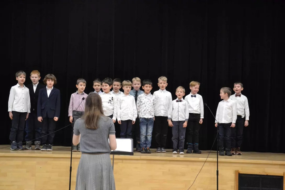 Uczniowie klasy 1d śpiewający w czasie świątecznej uroczystości klas wczesnoszkolnych. 