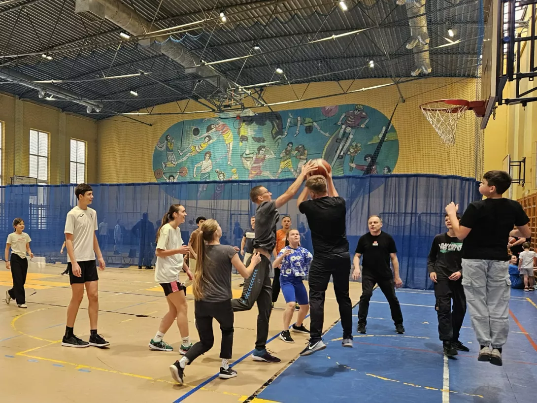 Uczniowie z rodzicami grają w koszykówkę