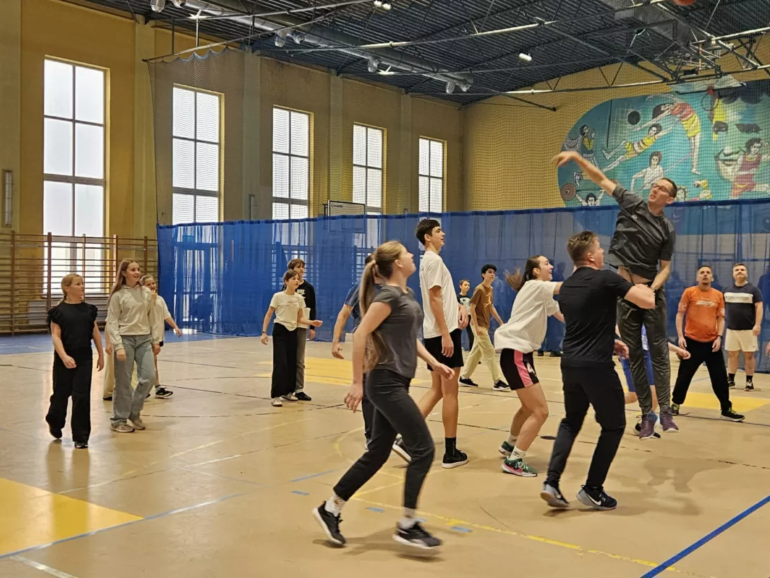 Uczniowie z rodzicami grają w koszykówkę