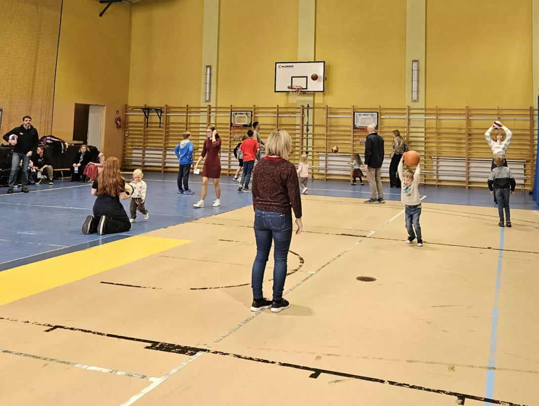 Uczniowie z rodzicami w hali sportowej