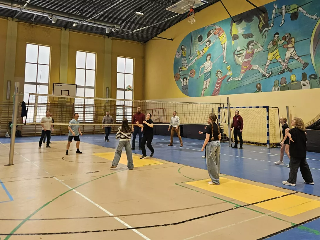 Uczniowie z rodzicami grają w siatkówkę