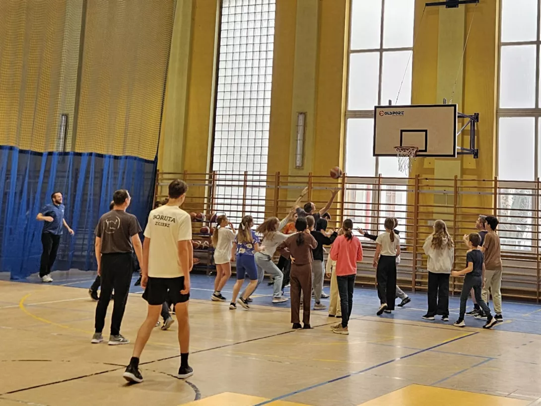 Uczniowie z rodzicami grają w koszykówkę
