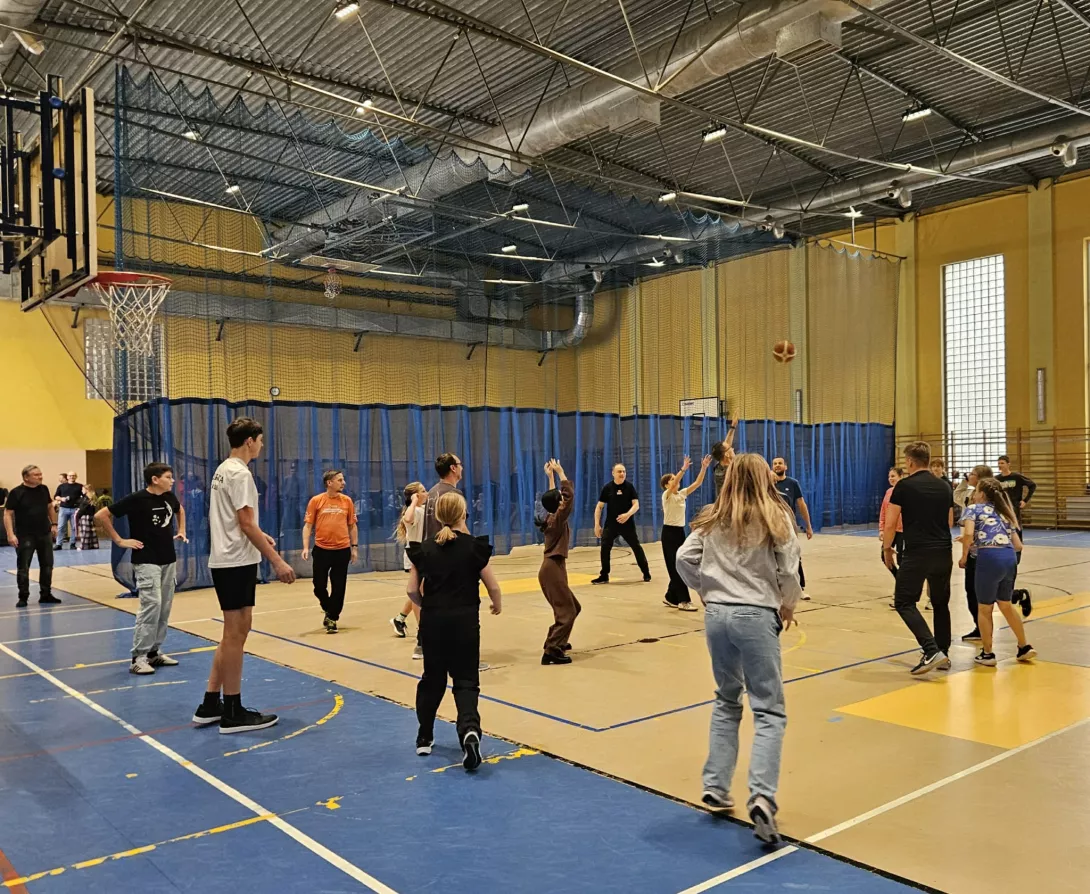 Uczniowie z rodzicami grają w koszykówkę