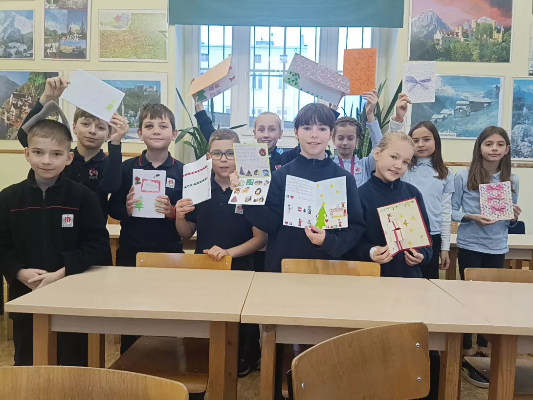 Uczniowie z kartkami świątecznymi