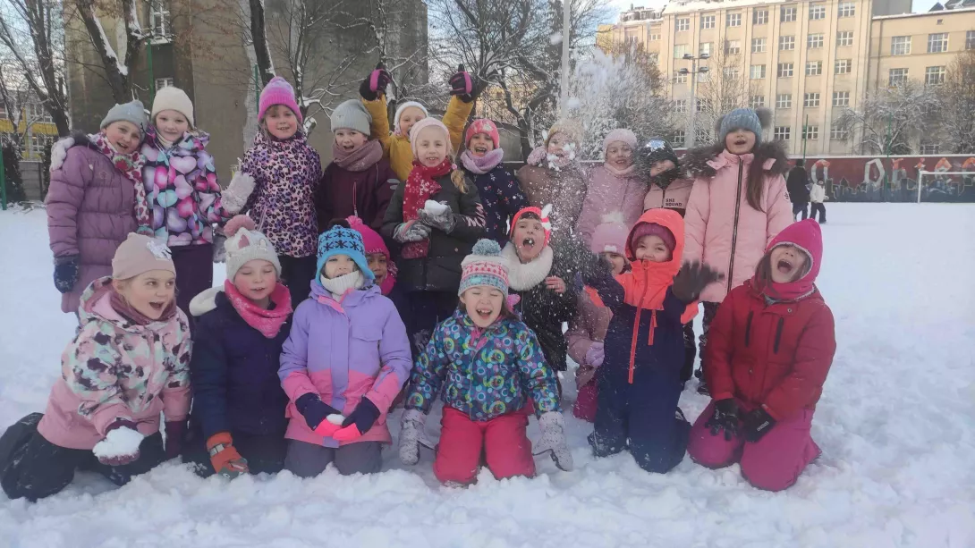 Klasa 1a podczas zabawy na śniegu na szkolnym boisku 