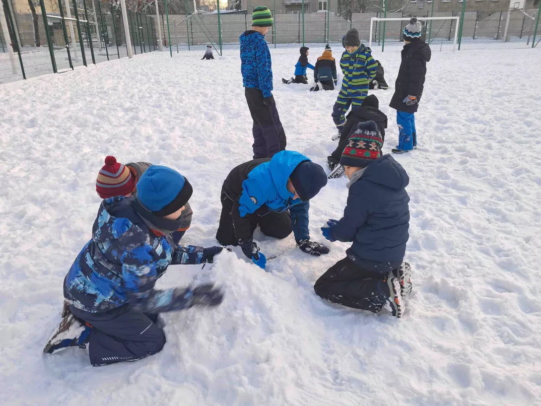 Chłopcy z klasy 3b budujący ze śniegu na szkolnym boisku 
