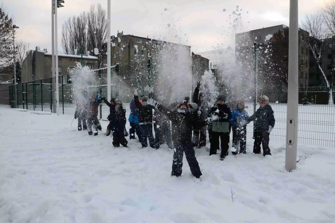 Klasa 2b podczas zabawy na śniegu na szkolnym boisku 
