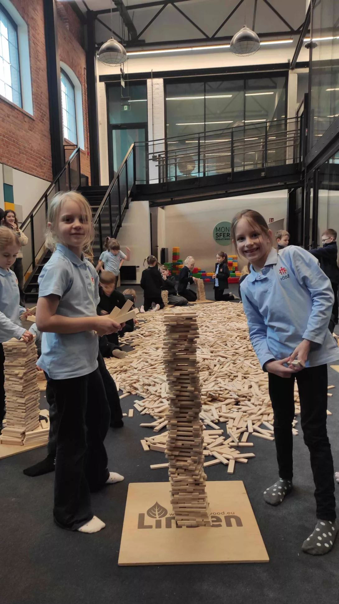 Uczennice klasy 1a SSP pozujące do zdjęcia ze swoją wieżą z klocków Linden 