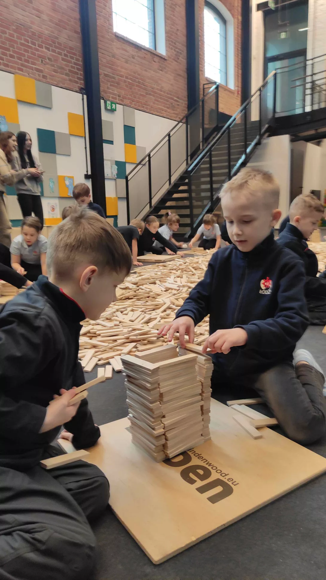 Chłopcy z klasy 1b SSP budujący wieżę z drewnianych klocków Linden 
