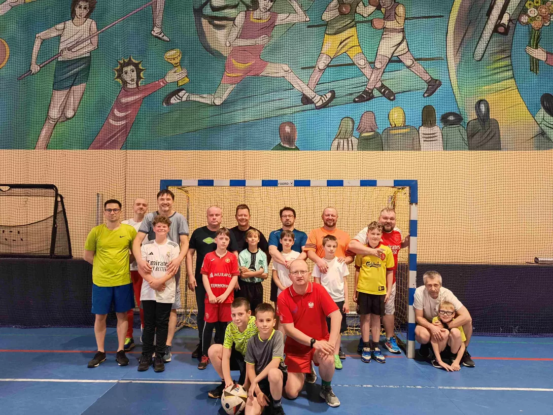 Mecz synowsko-ojcowski w 4b na hali sportowej, zdjęcie grupowe