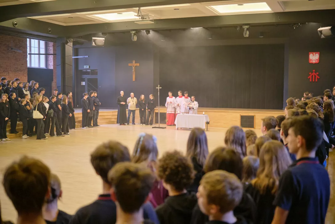 Ks. Dyrektor w asyście ministrantów prowadzi szkolną kolędę podczas Słówka dla SLO (fot. Amelia Szymańska)