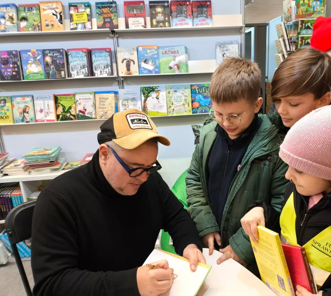 Pan Grzegorz Kasdepke podpisuje książkę. 