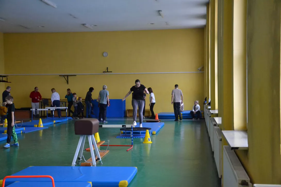 Jedna z mam pokonuje tor przeszkód przygotowany przez synów i tatusiów.