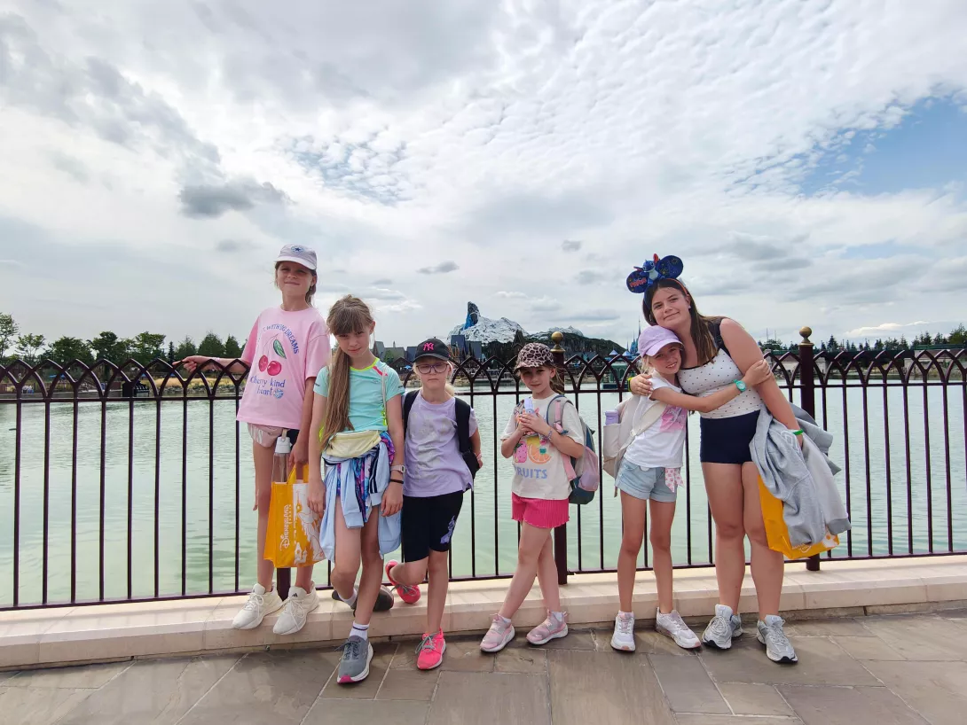 Uczestnicy wyjazdu a w tle wioska z Krainy Lodu w Disneylandzie.