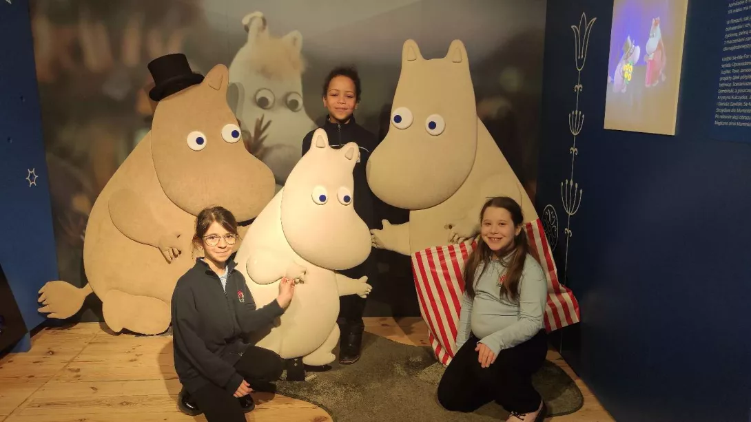 Dziewczynki w towarzystwie Muminków podczas zwiedzania wystawy "Muminki, drzwi zawsze otwarte" w Muzeum Kinematografii w Łodzi 