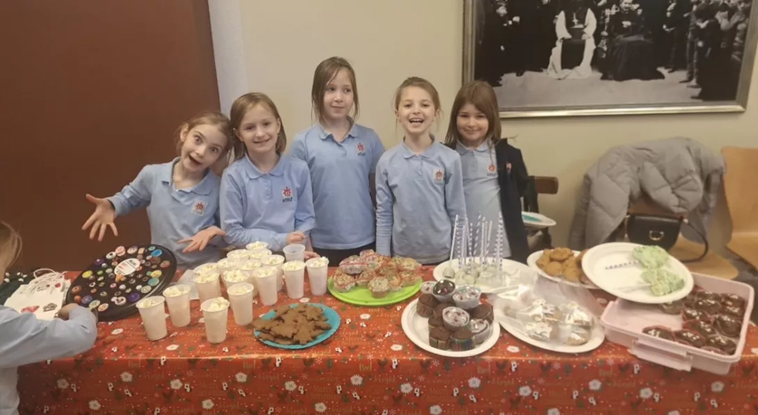 Uczennice klasy 2c sprzedające przekąski i dekoracje podczas świątecznego kiemaszu.