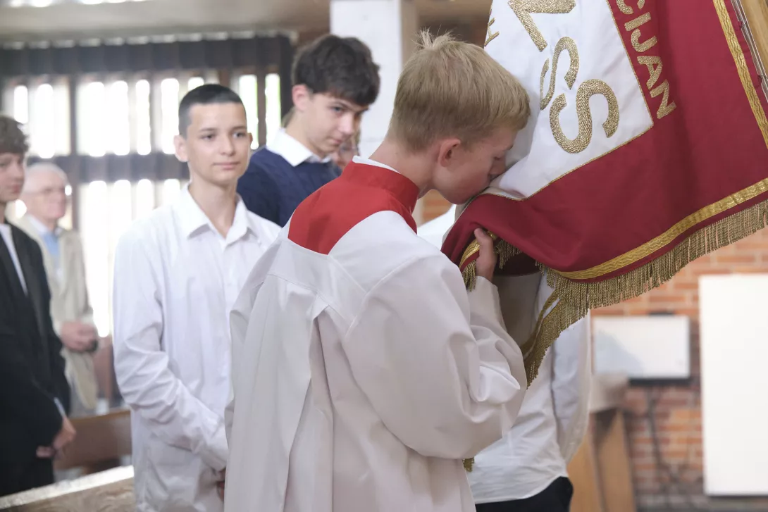 Uczeń klasy 1 SLO całuje sztandar szkoły. (fot. Antonii Szumielewicz)