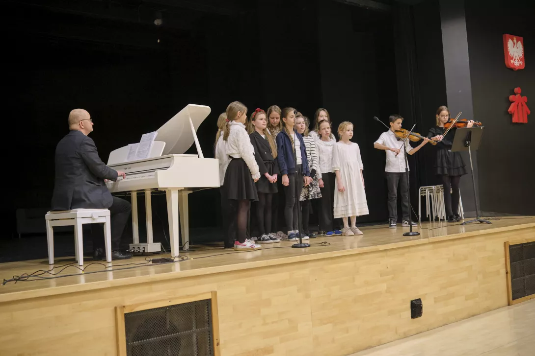 Schola szkoły podstawowej gra i śpiewa kolędy.