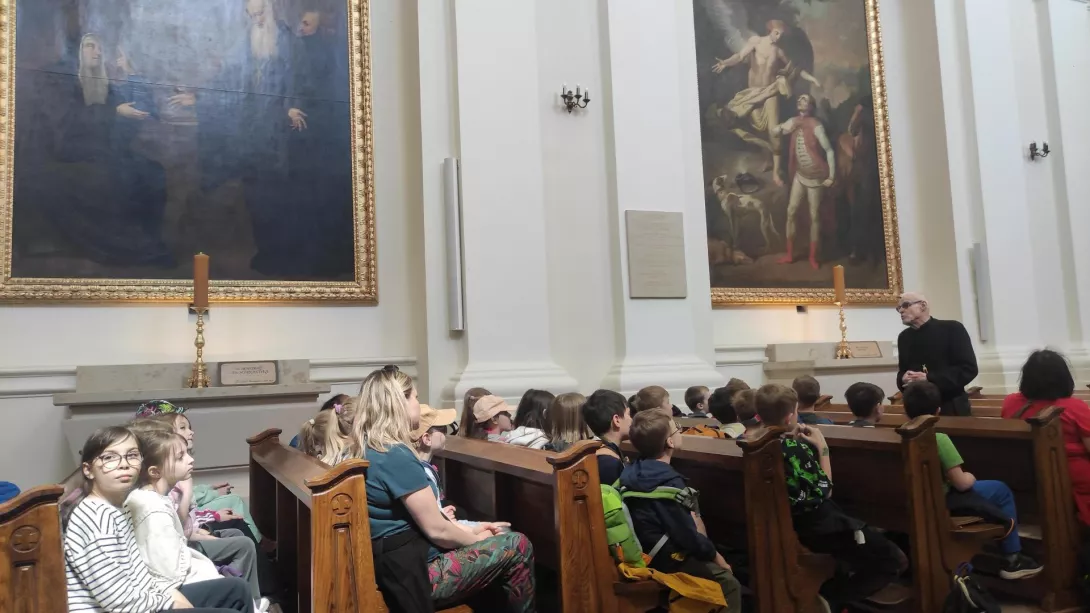 Uczestnicy wycieczki słuchają historii klasztoru na Świętym Krzyżu 