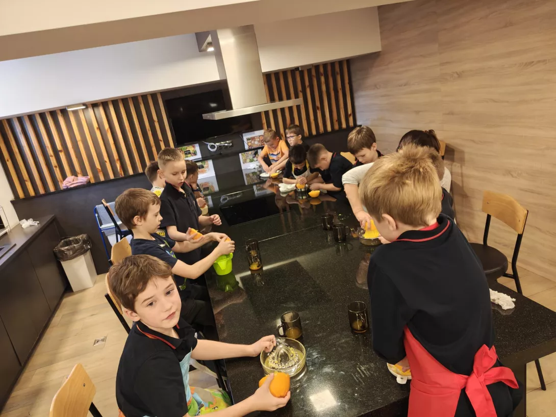 Uczniowie z klasy 1b wyciskają sok z pomarańczy. 